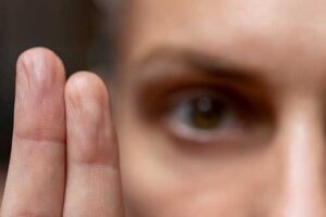 after a womans emdr program she holds up her two fingers while her eye is focused in the background 