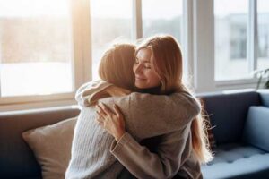 two women embrace in a hug at a residential treatment program