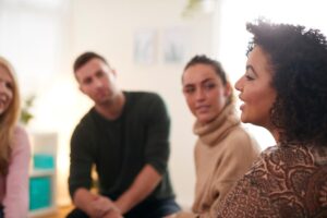 a woman speaks in a group therapy session as part of her relapse prevention therapy